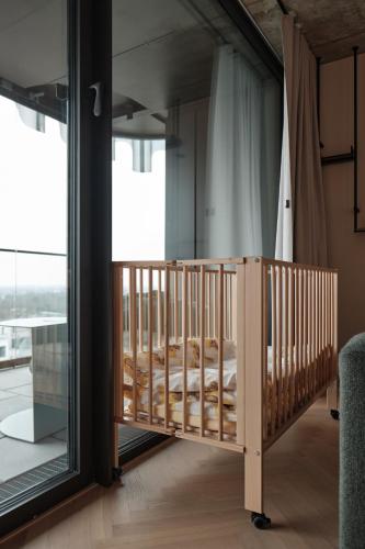 a wooden crib in a room with a large window at The Zipper Hotel und Apartments in Düsseldorf