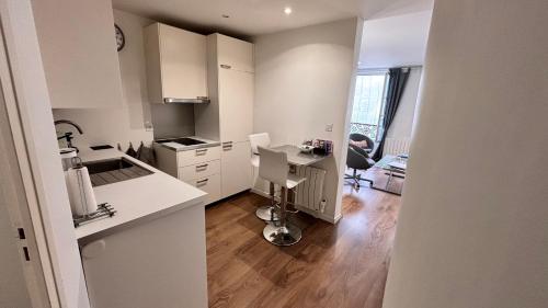 une cuisine avec des placards blancs et un bureau. dans l'établissement Charmant apartment in Monmartre, à Paris