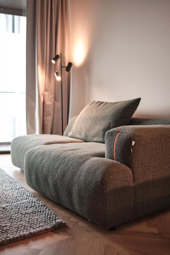a couch sitting on the floor in a living room at The Zipper Hotel und Apartments in Düsseldorf