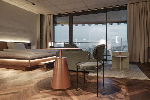 1 dormitorio con 1 cama, mesa y sillas en The Zipper Hotel und Apartments en Düsseldorf
