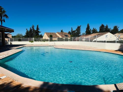 a large pool of blue water in a yard at Petite villa au calme dans résidence avec piscine in Fréjus