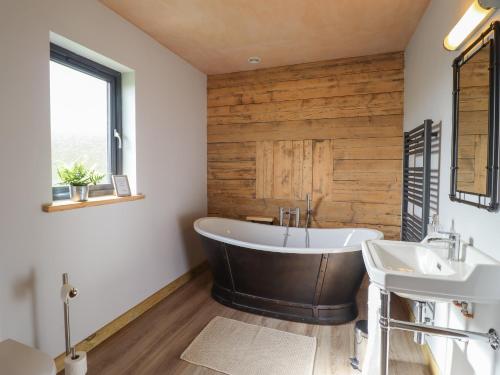 a bathroom with a tub and two sinks at Bwncath in Welshpool