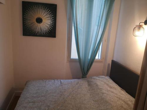 - une chambre avec un lit doté d'un rideau bleu et d'une fenêtre dans l'établissement Appartement Mourillon à 80m des plages, à Toulon