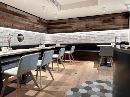 a restaurant with tables and chairs and a brick wall at Hotel Berliner Hof by Coffee Fellows Hotels in Kiel