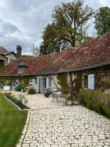 a house with a stone driveway in front of it at La Forge de Malpas in Quingey