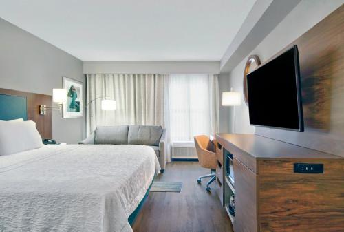 a hotel room with a bed and a flat screen tv at Hampton Inn Ft Lauderdale Airport North Cruise Port in Fort Lauderdale