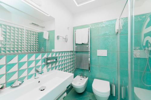 a blue and white bathroom with a toilet and a sink at Hotel Miramare in Maiori