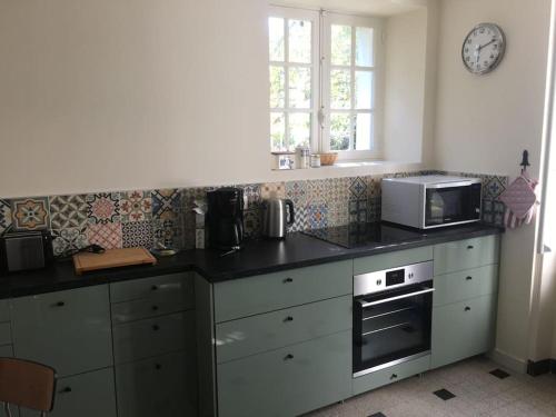 a kitchen with a counter top with a microwave at A 2’ du port & du bourg maison spacieuse in La Trinité-sur-Mer
