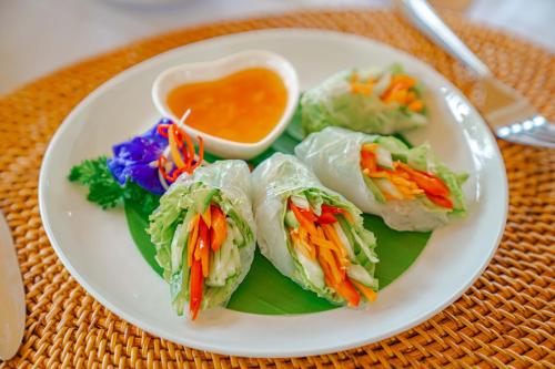 een wit bord met vier sandwiches op een tafel bij Tulus Hati Ubud Retreat in Ubud