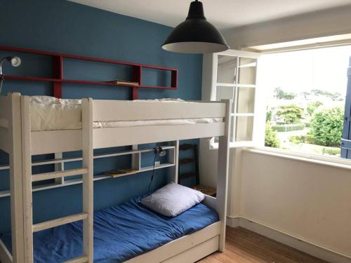 a bunk bed in a room with a blue wall at A 2’ du port & du bourg maison spacieuse in La Trinité-sur-Mer