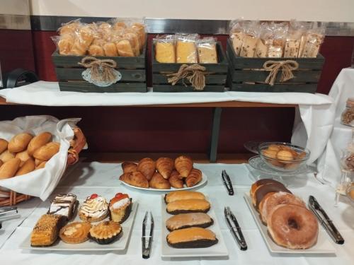 uma mesa com muitos tipos diferentes de pastelarias e pão em Hotel Ciudad Cangas de Onis em Cangas de Onís