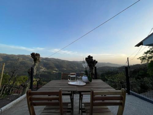 a wooden table with two glasses on it with a view at Refúgio da Mariana - Gerês in Terras de Bouro