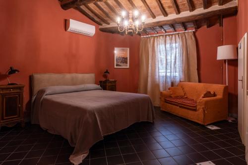 een slaapkamer met een bed en een stoel bij BirBo Bike Hospitality in Siena