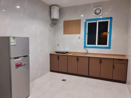 eine Küche mit einem Kühlschrank und einem Fenster in der Unterkunft الديار الفاخرة - الربوة in Dschidda