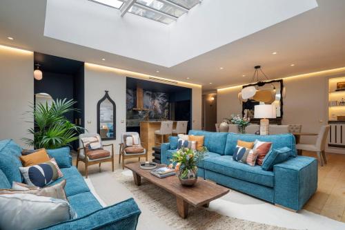 un salon avec des canapés bleus et une table dans l'établissement La Villa Ballu, à Paris