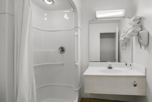 a white bathroom with a shower and a sink at Americas Best Value Inn - Lincoln Airport in Lincoln