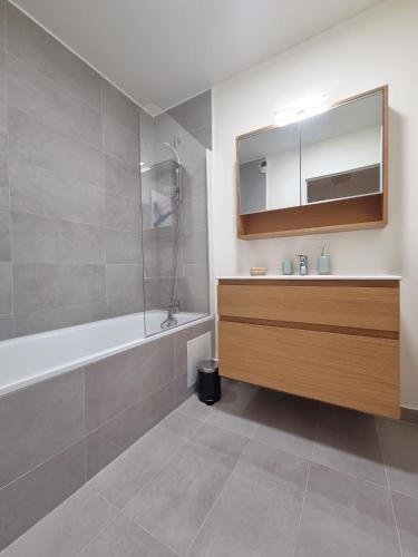 une salle de bain avec une baignoire, un lavabo et un miroir dans l'établissement 6P/terrasse/2 car parks/5min Paris, au Kremlin-Bicêtre