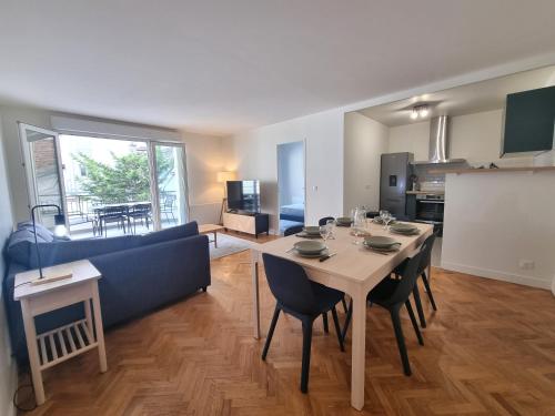 un salon avec une table et un canapé bleu dans l'établissement 6P/terrasse/2 car parks/5min Paris, au Kremlin-Bicêtre