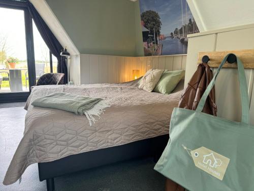 een slaapkamer met een bed met een draagtas bij Hotelhuisjes Medemblik in Wieringerwerf