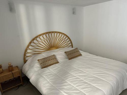 un lit blanc avec deux oreillers dessus dans l'établissement Appartement 2 pièces face à l'océan-Hourtin Plage, à Hourtin