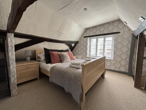 a bedroom with a large bed and a window at Cromwell Cottage in Fakenham