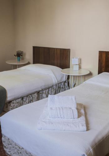 two beds with white towels on them in a room at Agriturismo Montevecchio Isolani in Monte San Pietro