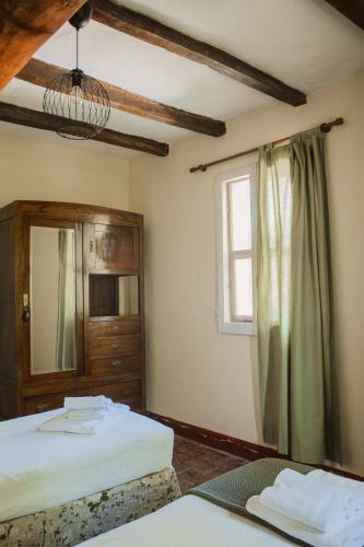 a bedroom with two beds and a window at Agriturismo Montevecchio Isolani in Monte San Pietro