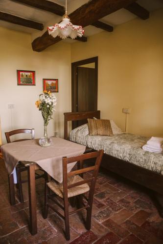 a room with two beds and a table and chairs at Agriturismo Montevecchio Isolani in Monte San Pietro