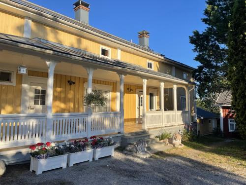una casa vieja con flores delante en Vinter Bed & Breakfast, en Sauvo