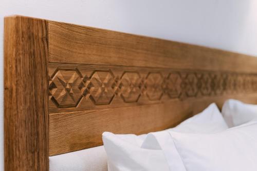 a wooden headboard of a bed with white pillows at MATCA Transylvanian Sanctuary in Şimon