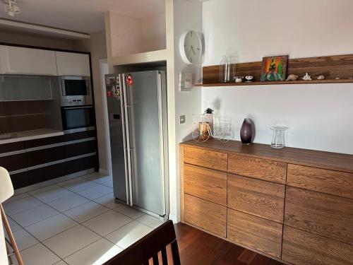 uma cozinha com um frigorífico de aço inoxidável e armários de madeira em Apartament Nad Zalewem em Rzeszów