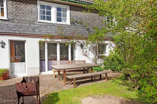 a picnic table and chairs in front of a house at Ferienwohnung am Marienbach in Kirchhundem