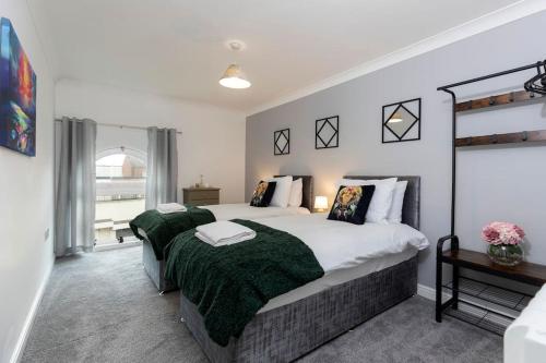 a bedroom with a large bed with a green blanket at Albert Park View (free parking!) in Middlesbrough