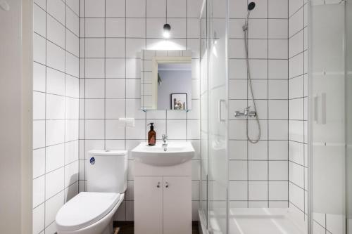 y baño con aseo, lavabo y ducha. en Solo Society Kaunas Apartments en Kaunas