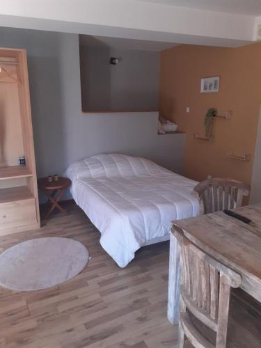 um quarto com uma cama branca e uma mesa em Auberge des 7 ecluses em Rogny