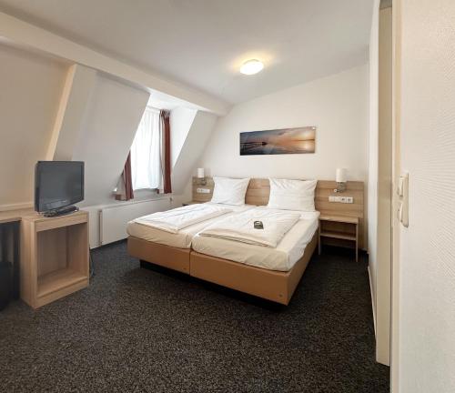 a hotel room with a bed and a television at Hotel Berliner Hof in Kiel