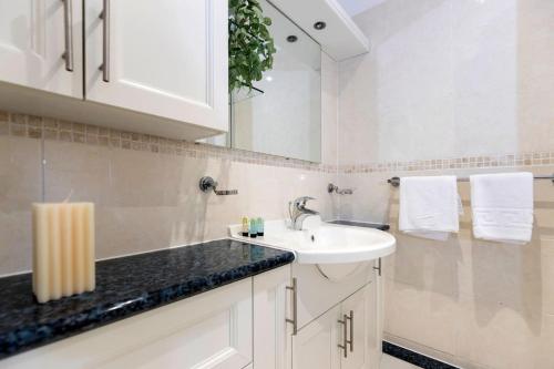 a white bathroom with a sink and a mirror at Albert Park View (free parking!) in Middlesbrough