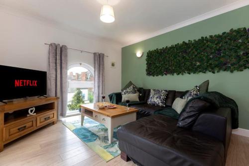 a living room with a couch and a flat screen tv at Albert Park View (free parking!) in Middlesbrough