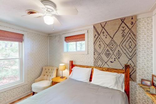 een slaapkamer met een bed, een stoel en een raam bij Jewelbox Cottage in Huddleston