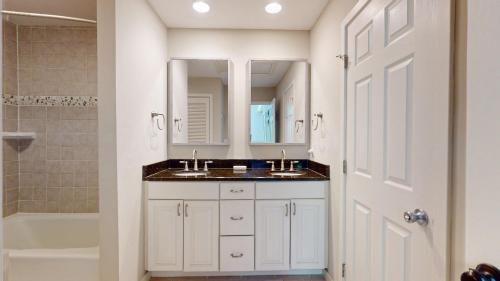 Baño blanco con lavabo y espejo en 284 Turnberry Village, en Hilton Head Island