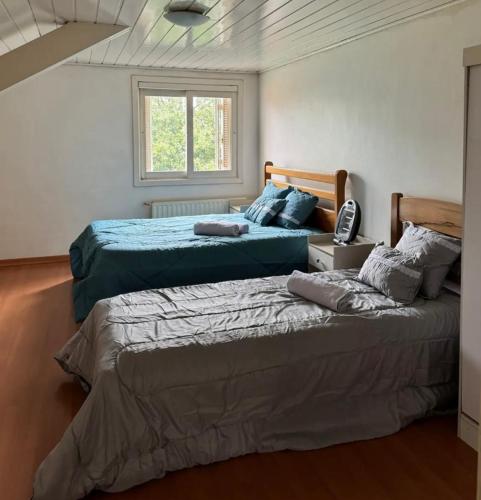 Duas camas sentadas uma ao lado da outra num quarto em Apartamento Aconchego Gramado em Gramado