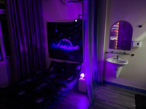 a purple room with a couch and a sink at LOPO homestay Ba Tháng Hai in Ho Chi Minh City