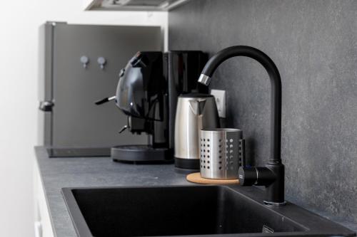 a kitchen counter with a sink and a coffee maker at Piazza del Lago Suites - Menaggio in Menaggio