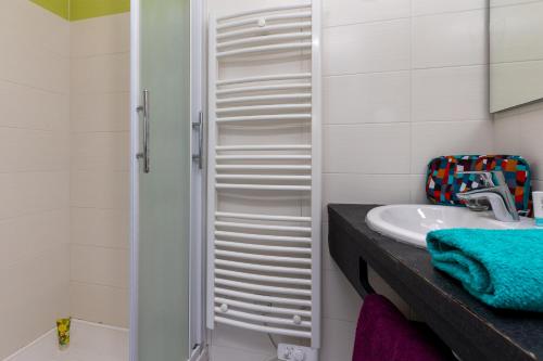 ein Badezimmer mit Waschbecken und Dusche in der Unterkunft Chalet cosy - vacances en famille in Léon