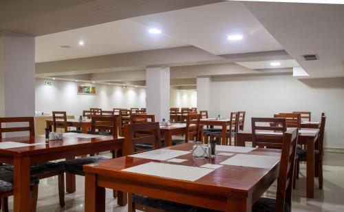 een eetkamer met houten tafels en stoelen bij Ribai Hotels Santa Marta in Santa Marta
