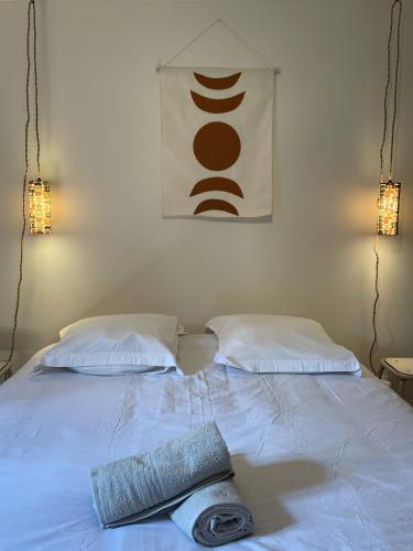 - un lit blanc avec 2 oreillers et une serviette dans l'établissement Les appartements d'Albertine - Clémence, à Bourges