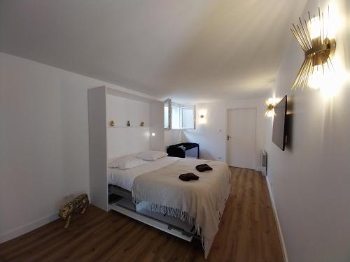 una camera da letto con un letto bianco in una stanza di L instant Chaumois - Moment zen aux Sables d Olonne a Les Sables-dʼOlonne