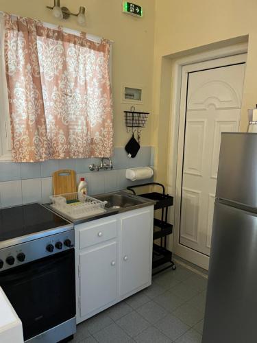a kitchen with a sink and a refrigerator at Studio Vasilis in Ýpsos