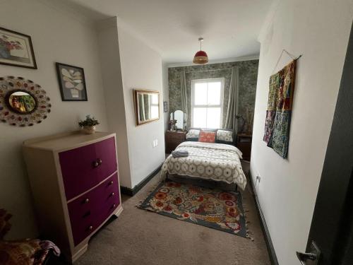 um quarto com uma cama, uma cómoda e uma janela em Cosy 2BR House Close to Burton-on-Trent Centre em Burton upon Trent