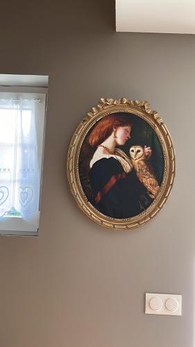 a framed picture of a woman holding a monkey on a wall at Le Terrier du sorcier in Floyon
